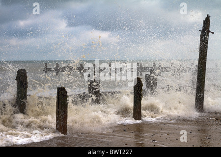 Vola a spruzzo dopo un'onda hits abbandonate le difese di mare sulla spiaggia di Happisburgh Foto Stock