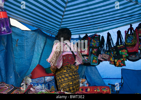 Una Kuna donna in costume tradizionale vende artigianato fatti da molas a una coperta in stallo Pedasi, Panama. Foto Stock