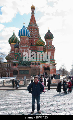 Un uomo in piedi di fronte a Cattedrale di San Basilio (Pokrovsky Sobor) nella Piazza Rossa di Mosca avente un turista foto scattata. Foto Stock