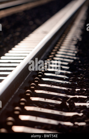 Acciaio lucido sulla rampa legami concreti contrassegnare una alta velocità traffico pesante railroad mainline. Foto Stock