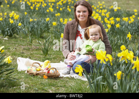 Madre e figlia In Daffodil campo decorato con le uova di Pasqua Foto Stock