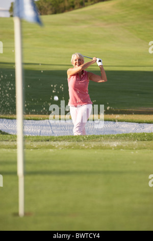 Senior Golfer femmina Bunker Shot Golf Foto Stock