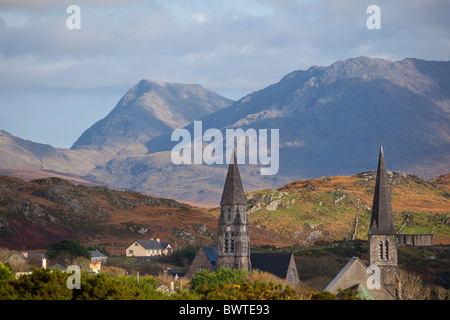 Guglie della chiesa del Connemara città di Clifden in Irlanda, con dodici Bens montagne sullo sfondo Foto Stock