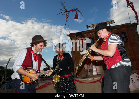 Il viaggio di una troupe di attori e musicisti intrattenere una folla nel giorno finale di Bestival 2010 a Newport, Isola di Wight Foto Stock