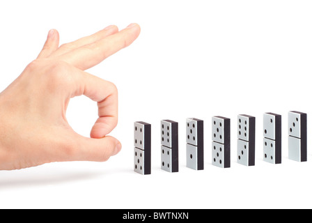 Pronto a mano per spingere l'effetto domino in una linea per provocare la reazione a catena Foto Stock