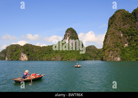 Mercato Galleggiante venditore nella baia di Halong, lasciando per la prossima barca, Vietnam Foto Stock