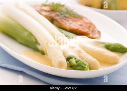 Verde e asparagi bianchi con il salmone selvatico e patate come primo piano su una piastra Foto Stock