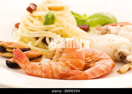 Spaghetti con gamberetti, cozze e seppia come primo piano su una piastra bianca Foto Stock