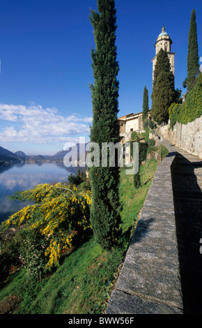 Svizzera Europa Morcote Cantone Ticino Lago di Lugano chiesa modo acqua di lago cipressi montagne mountain cy Foto Stock