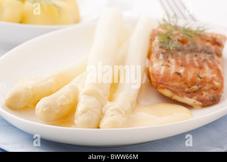 Verde e asparagi bianchi con il salmone selvatico e patate come primo piano su una piastra Foto Stock