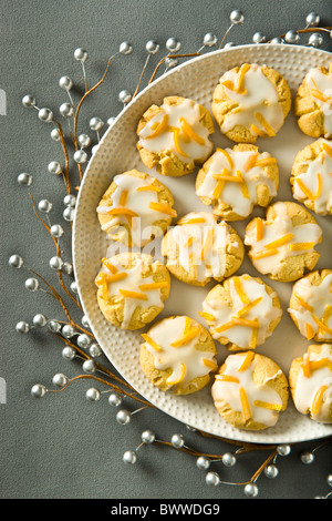 Orange biscotti al burro finito con la scorza di arancia ciliegina su una vacanza grigio Sfondo. Foto Stock