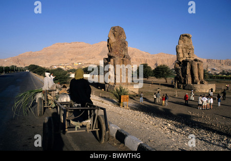 I turisti in visita a Colossi di Memnon, due enormi statue di pietra del faraone Amenhotep III, nella necropoli tebana, Luxor, Egitto Foto Stock