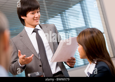 Foto di fiduciosa imprenditore spiegando la sua idea di colleghi in ufficio Foto Stock