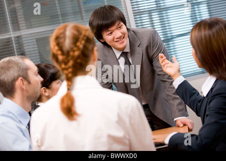 Foto di numerosi dipendenti a discutere di qualcosa con focus sul loro leader Foto Stock