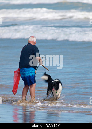 RACCOGLITRICE DI CROSTACEI CON IL SUO CANE E NET A GOOLWA BEACH SOUTH AUSTRALIA Foto Stock