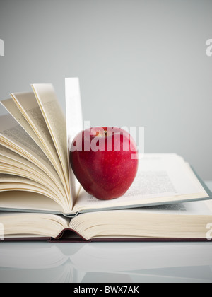 Pila di libri e mela rossa sulla scrivania. Spazio di copia Foto Stock