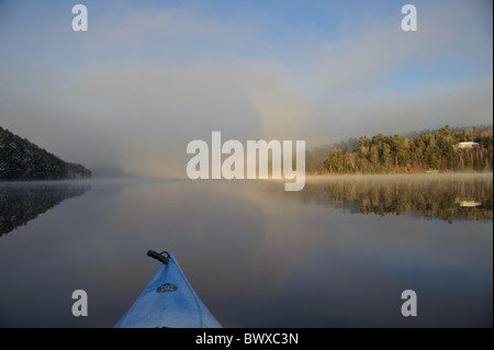 Kayaking sul San Giovanni fiume ai primi di dicembre dopo una nevicata fresca su un inizio di mattina con calma acqua chiara Foto Stock