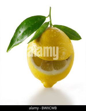 Tutto freschi Limoni con foglie e una faccina sorridente tagliare il limone contro white Foto Stock