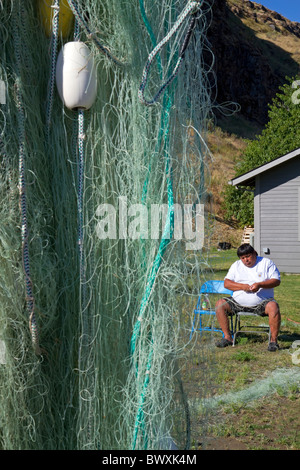 Yakama nazione indiana la riparazione di reti da pesca a Celilo villaggio sul fiume Columbia, Oregon, Stati Uniti d'America. Foto Stock