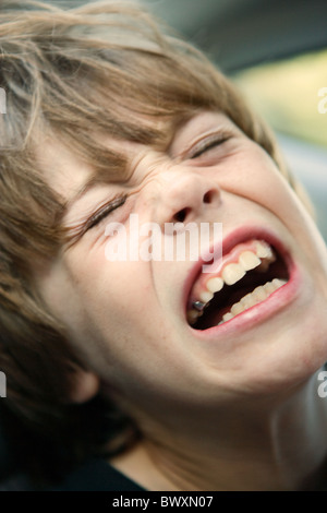 Bambino di otto anni che grida in agonia, vicino fino al viso. Foto Stock