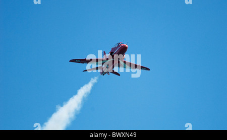 Solo le frecce rosse Hawk RAF in volo di fumo finale - cielo blu sullo sfondo Foto Stock