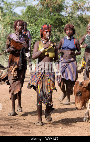 La sorella di avviare Dancing & soffiando il corno di ottone a Hamer Bull-jumping cerimonia, Valle dell'Omo, Etiopia Foto Stock