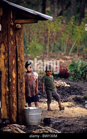 Due bambini guatemaltechi al di fuori di una casa in legno in un campo profughi vicino al confine, Santa Esmeralda, Chiapas, Messico. Foto Stock