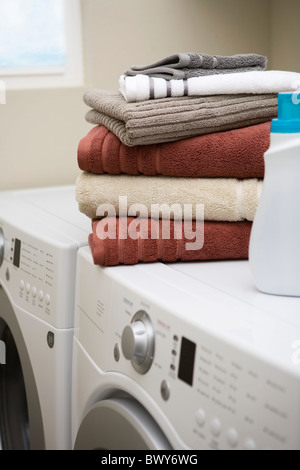 Pila di asciugamani puliti in lavatrice e asciugatrice Foto Stock