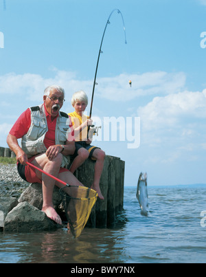 Ragazzo bambino cattura anziani uomo pesce pesca fishnet generazioni NIPOTE nonno asta di cerniera gioia il lago la Foto Stock