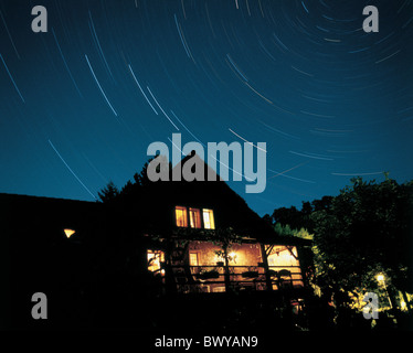 Di notte il crepuscolo per effetto home casa illuminata esposizione tempo di notte una casa di famiglia al di fuori di stelle del crepuscolo Foto Stock