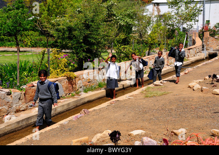 Un gruppo di bambini della scuola svolge nel condotto dell'acqua. Prince Albert, Sud Africa. Foto Stock