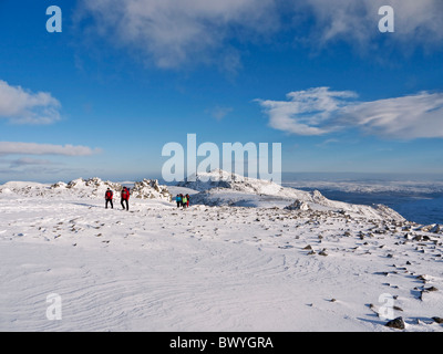 Hill walkers sul Glyder Fawr in inverno. Glyder Fach può essere visto in background. Snowdonia, il Galles del Nord Foto Stock