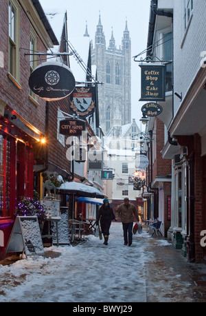 Canterbury centro città in inverno. Shoppers sfidando la neve nella norcineria Lane con la cattedrale in background. Foto Stock