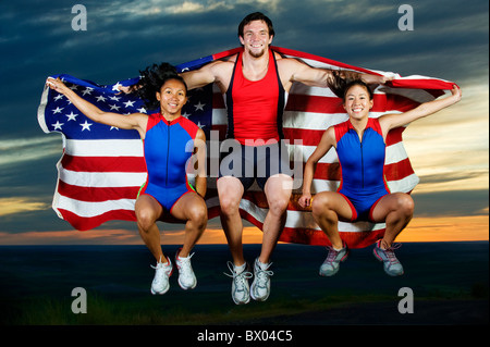Gli atleti del salto in mid-aria con bandiera americana Foto Stock
