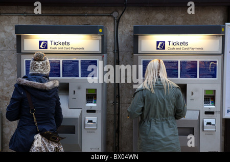 I passeggeri di acquistare i biglietti dalle macchine automatiche nella stazione centrale di Glasgow Foto Stock