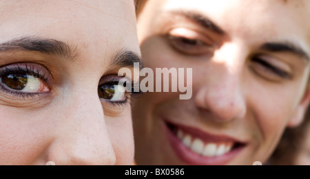 Un occhi di donna guardare a sinistra come suo marito la guarda dallo sfondo. Foto Stock