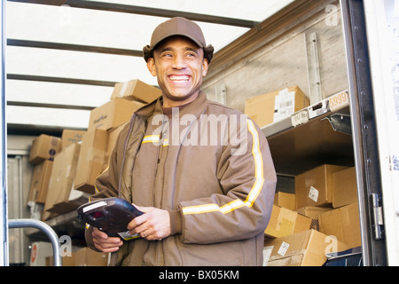 Sorridente consegna ispanica uomo in piedi nel retro del carrello Foto Stock