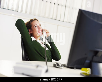 Donna che parla al telefono in ufficio Foto Stock