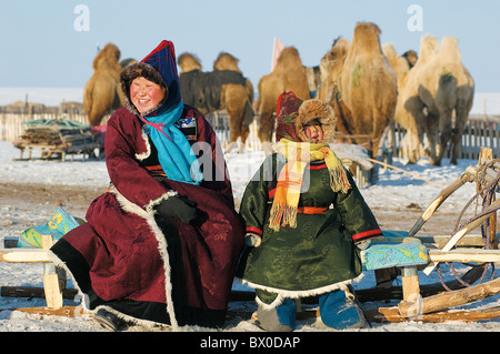 Buryats madre e figlio seduti su una slitta, Evenk Banner autonoma, Hulunbuir, Mongolia Interna, Cina Foto Stock