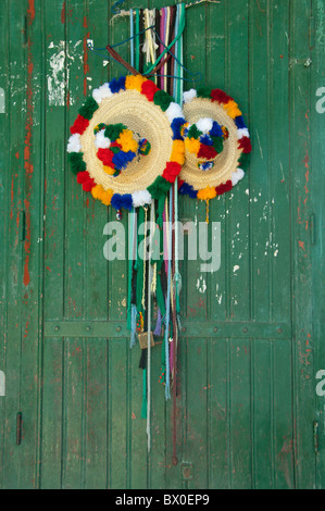 Il Marocco, Tetouan. Storica Medina bazaar. Agricoltore tradizionale di cappelli di paglia appesi su antichi verde porta di legno. Foto Stock