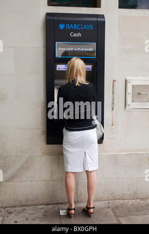 Donna con il cliente utilizzando un Bancomat presso la Barclays Bank ATM Automated Teller Machine a Londra il San Giovanni Bosco. DAVID MANSELL Foto Stock