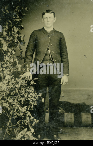 Giovane uomo che indossa a quattro pulsanti sacco rivestire in bianco e nero di tipo stagno fotografia 1860s a 1870 moda ritratto verticale americana Foto Stock