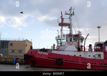 Vecchio rosso invecchiato rimorchiatore ormeggiato sul canale del fiume Tevere Roma Italia Europa Mediterraneo europeo italiano Foto Stock