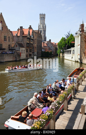 Rosario quay con turisti su Dijver Canal Cruise barche con campanile al di là. Rozenhoedkaai, Bruges, Fiandre Orientali, Belgio Foto Stock