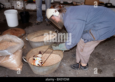 Fare ceramica Raku utilizzando un tradizionale riservato di cottura in ceramica Foto Stock