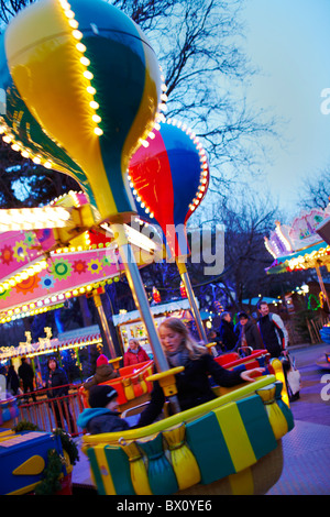 I bambini su fairground ride al crepuscolo Foto Stock