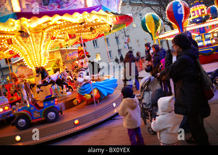 I bambini su fairground ride al crepuscolo Foto Stock