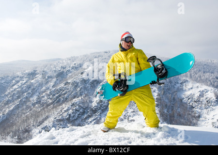 Ritratto di entusiasti dello sportivo con lo snowboard in piedi sulla cima del monte Foto Stock