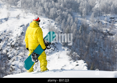 Vista posteriore di snowboarder in piedi il cumulo di neve in inverno Foto Stock