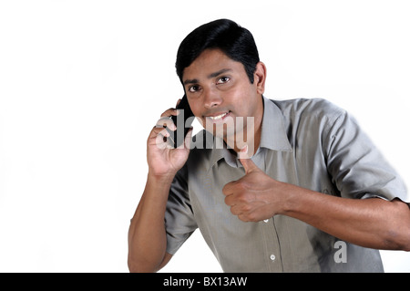 Un bel uomo indiano parlando al telefono Foto Stock